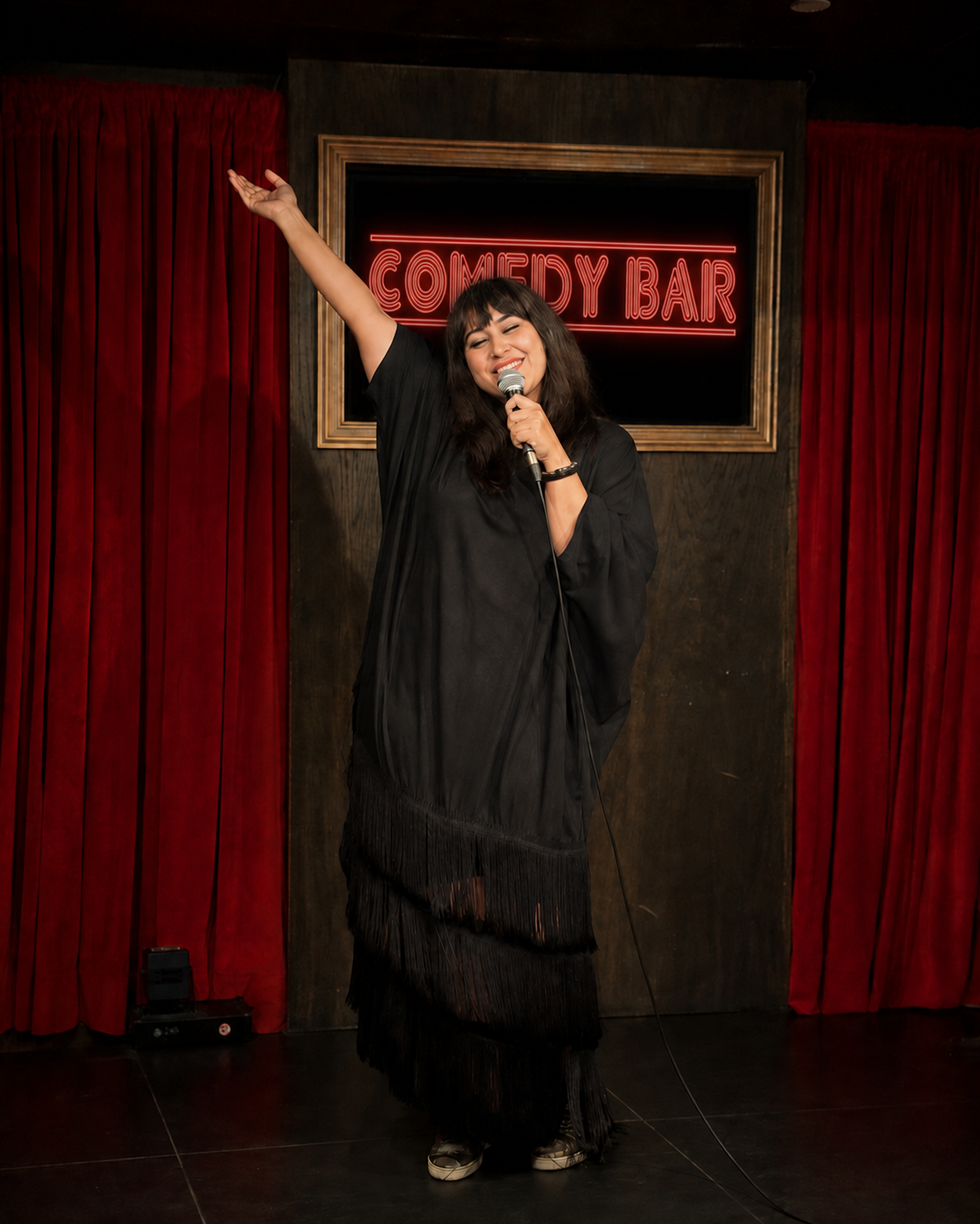 Geetika Khurana performing stand-up comedy on stage at a comedy bar